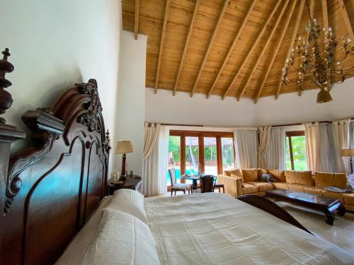 a bedroom with a large bed and a couch at 5-Bedroom Villa with Private Pool, Maid and Golf Course Views at Casa de Campo Resort in La Romana