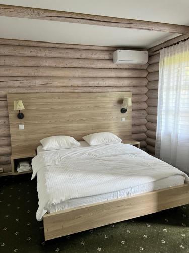 a bedroom with a large bed with a wooden headboard at Vik-Jan in Khmelnytskyi