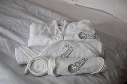 un mucchio di asciugamani sopra un letto di Ghazalle Oasis Hotel 1 a El Biar