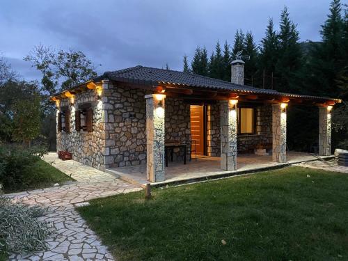 a small stone house with lights on it at Το πετρινο σπιτι του Καστρη! Με θεα τα Μετεωρα in Kalabaka