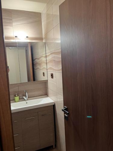 a bathroom with a sink and a wooden door at Το πετρινο σπιτι του Καστρη! Με θεα τα Μετεωρα in Kalabaka