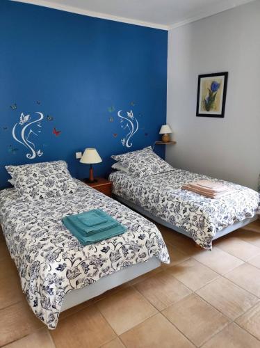 une chambre avec deux lits et un mur bleu dans l'établissement GITE AUX 4 SAISONS DU COLORADO PROVENÇAL - 3 ÉTOILES - Rustrel, à Rustrel