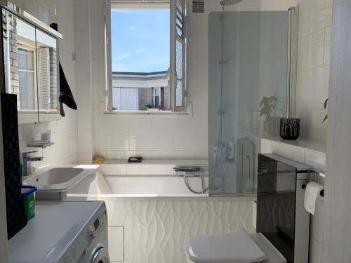uma casa de banho com uma banheira, um lavatório e um WC. em L'Escapade parisienne em Paris
