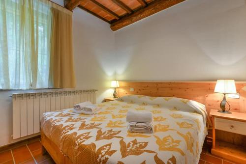 - une chambre avec un lit et 2 serviettes dans l'établissement Rifugio Rustico Relax in Parco Privato - free parking - privacy TG4, à Castel del Piano