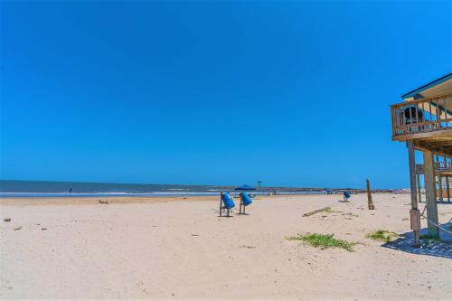 a person sitting in a chair on the beach at Hot Tub and Jacuzzi Suite! 100 steps from spacious beach and Jetty park! Generations Retreat Sleeps 26 in Surfside Beach