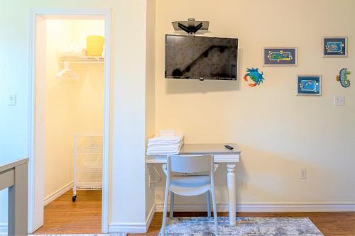 a room with a desk with a television on the wall at Hot Tub and Jacuzzi Suite! 100 steps from spacious beach and Jetty park! Generations Retreat Sleeps 26 in Surfside Beach