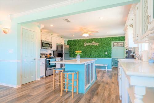 a kitchen with blue walls and a green accent wall at Hot Tub and Jacuzzi Suite! 100 steps from spacious beach and Jetty park! Generations Retreat Sleeps 26 in Surfside Beach