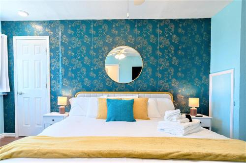 a bedroom with a large bed and a mirror at Hot Tub and Jacuzzi Suite! 100 steps from spacious beach and Jetty park! Generations Retreat Sleeps 26 in Surfside Beach