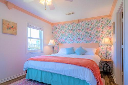 a bedroom with a bed with a red and blue blanket at Hot Tub and Jacuzzi Suite! 100 steps from spacious beach and Jetty park! Generations Retreat Sleeps 26 in Surfside Beach