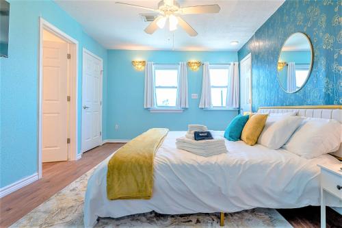 a bedroom with a large bed with blue walls at Hot Tub and Jacuzzi Suite! 100 steps from spacious beach and Jetty park! Generations Retreat Sleeps 26 in Surfside Beach