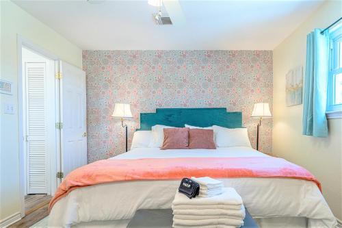 a bedroom with a large bed with a blue headboard at Hot Tub and Jacuzzi Suite! 100 steps from spacious beach and Jetty park! Generations Retreat Sleeps 26 in Surfside Beach