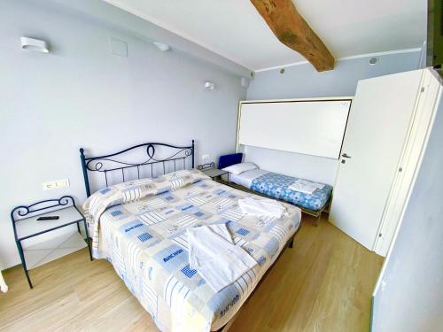 a bedroom with two beds and a white wall at Apartment La Scogliera - Riomaggiore in Riomaggiore
