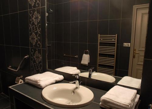 a bathroom with two sinks and a mirror at Le Logis du Péré in Saint-Coutant-le-Grand