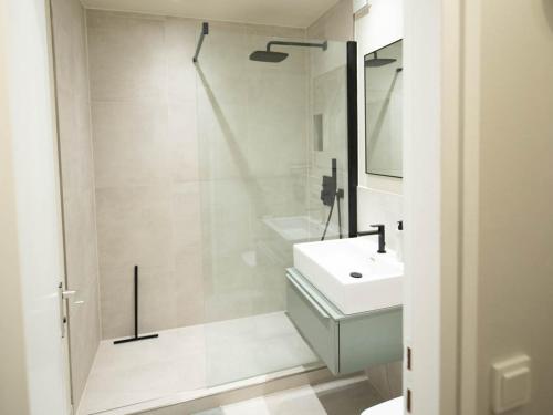 a white bathroom with a sink and a shower at Stylisches Design-Apartment in Bad Tölz