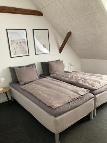 a large bed in a bedroom with two pictures on the wall at Varde Bed and Kitchen in Varde