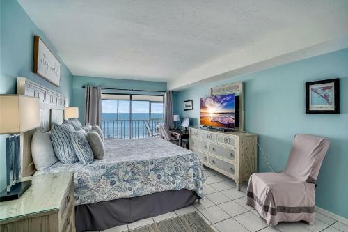a bedroom with a bed and a view of the ocean at Arie Dam 304 in St. Pete Beach