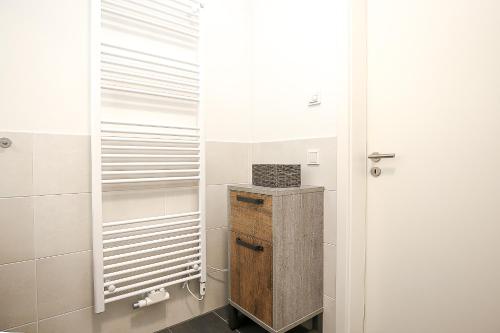 ein Bad mit einem begehbaren Kleiderschrank und einer Tür in der Unterkunft Weiße Villen Wohnung 19 in Boltenhagen