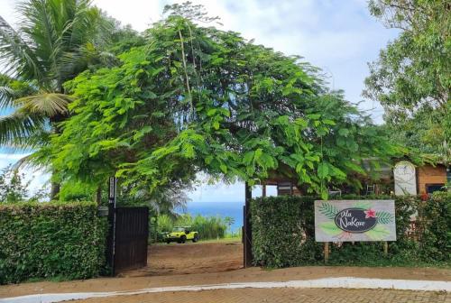 um sinal em frente a uma cerca com uma árvore em Pousada Vila Nakau em Fernando de Noronha