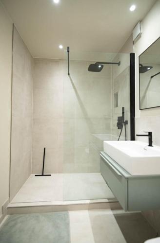 a white bathroom with a sink and a mirror at Stylisches Design-Apartment in Bad Tölz
