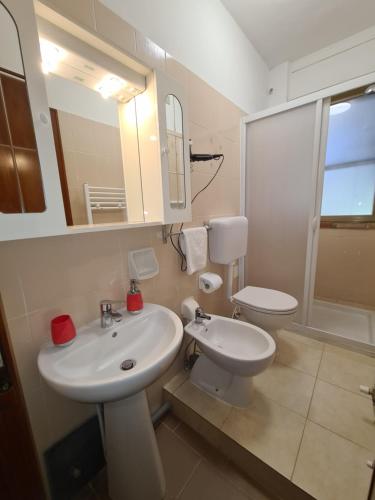 Baño blanco con lavabo y aseo en Camere al Mare, en Lido di Camaiore