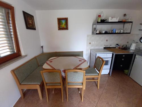 a kitchen with a table and chairs in a kitchen at Peaceful, cosy cottage near Kolpa river in Gradac