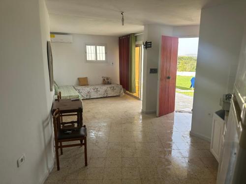 einen Flur mit einem Schlafzimmer mit einem Bett und einem Stuhl in der Unterkunft DAR AROUA S3 avec jardin gazonné in El Haouaria