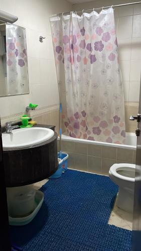 a bathroom with a tub and a toilet and a shower curtain at Hostel - bedspace for Ladies سكن - سرير للبنات in Al Khān