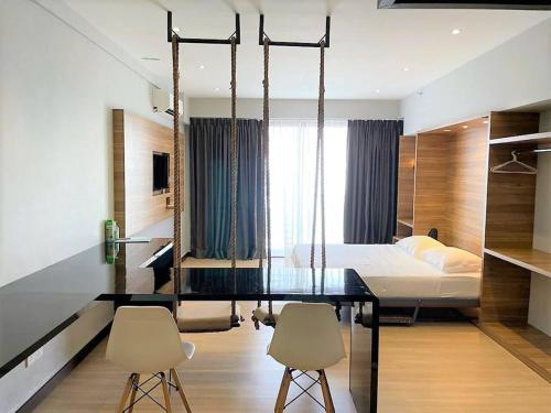 a bedroom with a bed and a desk and chairs at Aeropod SOVO Entire Serviced Studio in Kota Kinabalu