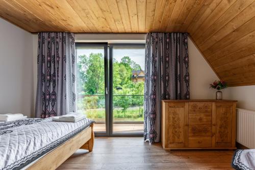 een slaapkamer met een bed en een groot raam bij Chata Herkulesa in Zakopane