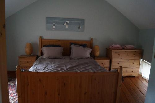 1 dormitorio con 1 cama de madera y 2 vestidores en La Petite Maison, en Sart lez Walhain
