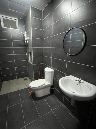 bagno con lavandino, servizi igienici e specchio di Ilsham Guest House @ Seroja Hills BBST Sepang a Sepang