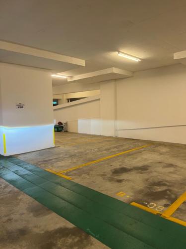 a large empty parking garage with a green line at Ilsham Guest House @ Seroja Hills BBST Sepang in Sepang