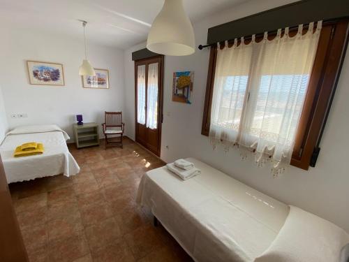 1 dormitorio con 2 camas y ventana en ADOSADO CON VISTAS, RELAJATE Y DISFRUTA, en Ayamonte