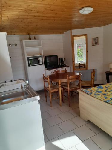 une cuisine et une salle à manger avec une table et un réfrigérateur dans l'établissement Le Vintage, aux Herbiers