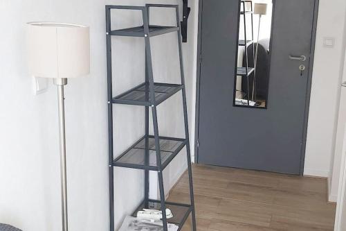 une étagère noire dans une pièce avec une lampe dans l'établissement Cosy studio centre-ville, balcon, à Nantes