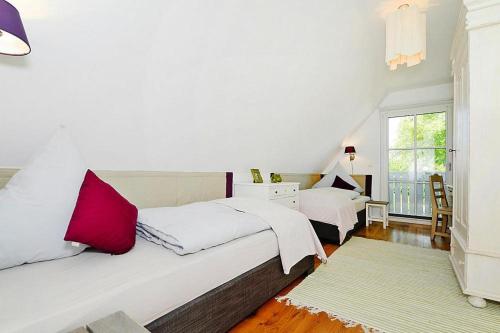 Un dormitorio blanco con dos camas y una ventana. en Ferienwohnung in Wyk auf Foehr, en Wyk auf Föhr