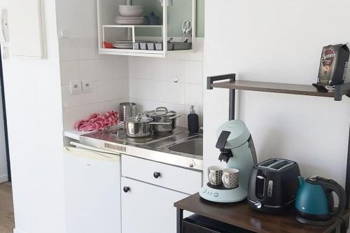 une cuisine avec un évier et une cuisinière four supérieur dans l'établissement Cosy studio centre-ville, balcon, à Nantes