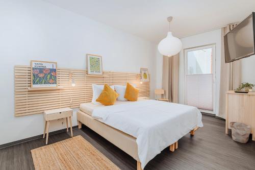 a bedroom with a bed and a flat screen tv at Altstadtbude 27 - modernes Apartment in historischer Altstadt in Rostock