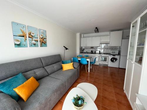 sala de estar con sofá gris y cocina en COSTA MARIÑA Fabuloso apartamento en la costa, en O Vicedo
