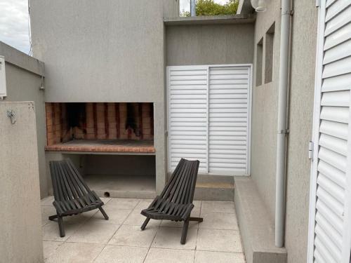 two chairs sitting on a patio with a fire place at APART LUCIA in Esperanza