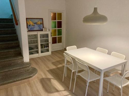 a dining room with a white table and chairs at Can Julián in L'Escala