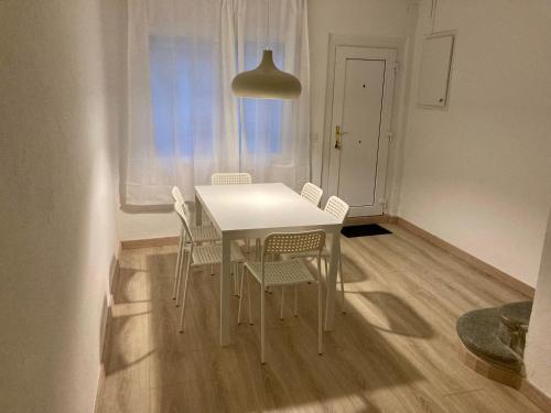 einen weißen Tisch und Stühle in einem Zimmer mit Fenster in der Unterkunft Can Julián in L'Escala