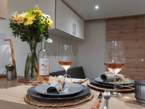 - une table avec deux verres de vin et des fleurs dans l'établissement ღUrban Cocon PARKING Centre historique, à Manosque