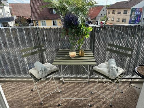 d'une table verte et de deux chaises sur le balcon. dans l'établissement Stilvolles und modernes Appartement mit sonnigem Balkon in Flughafen- und Messenähe 31, à Leinfelden-Echterdingen