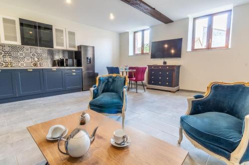 un salon avec des chaises bleues et une table dans l'établissement LA BUANDERIE, à Jonzac
