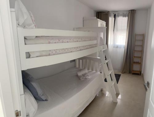 a white bunk bed in a small room at Apartamento Turístico Julia Gemella Acci in Guadix