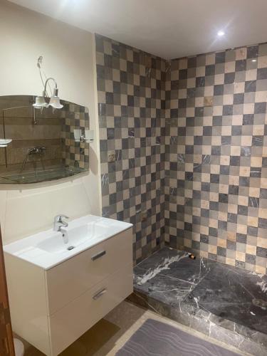 a bathroom with a sink and a tiled wall at Malabata Hills Retreat in Tangier