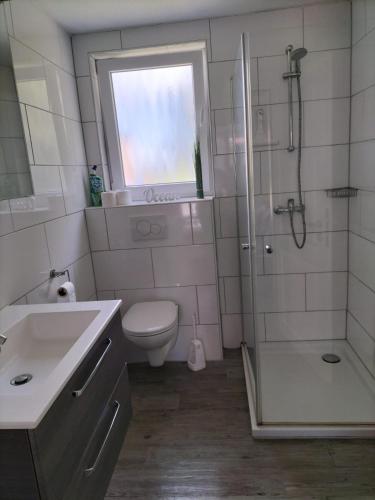 a bathroom with a toilet and a shower and a sink at FeWo Nordsee Whng 2 in Wangerland