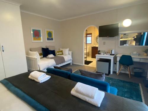 uma sala de estar com uma cama, um sofá e uma televisão em Dolphin Circle Bed and Breakfast em Plettenberg Bay