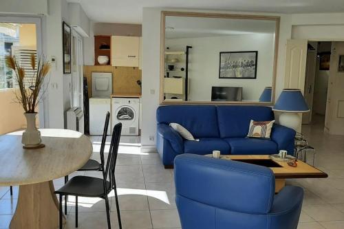 un salon avec un canapé bleu et une table dans l'établissement Nouveau cœur de ville, 100 m de la plage, spacieux, à Sainte-Maxime
